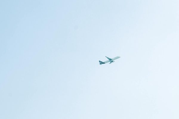 Um avião de passageiros voa por um céu azul e límpido, transmitindo a sensação de viagem e liberdade.